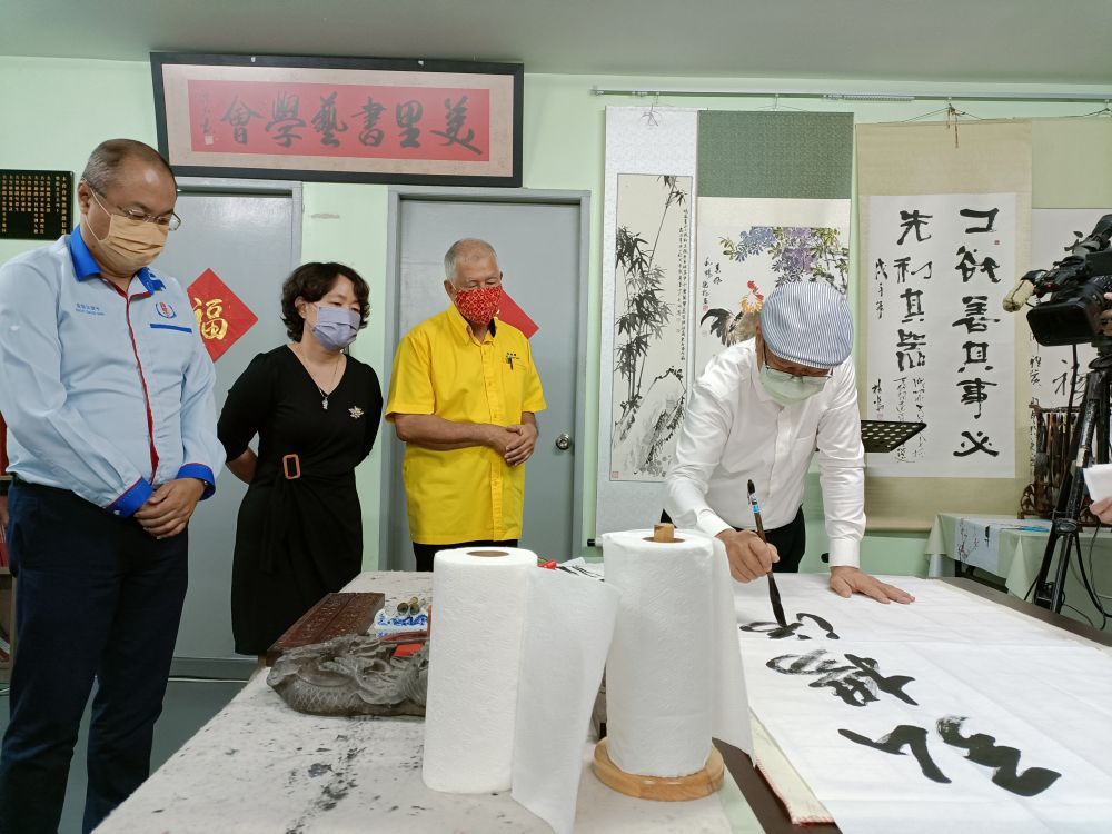 (Dari tengah) Ting, Kam dan Goh menyaksikan demonstrasi tulisan kaligrafi Cina di premis Pertubuhan Budaya dan Kaligrafi Cina di Permyjaya, Miri hari ini.