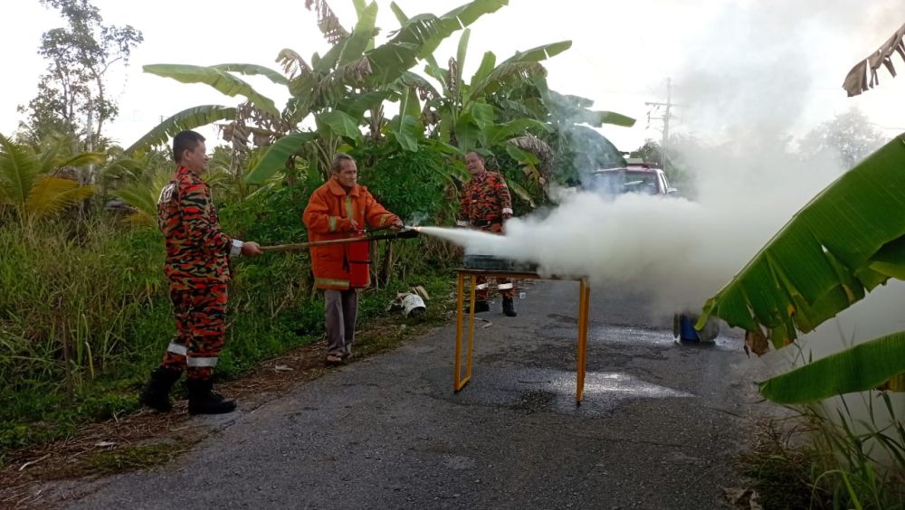 Penduduk diberi peluang mengendalikan alat pemadam api mudah alih untuk memadam kebakaran.