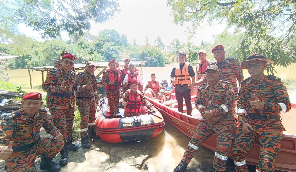 Ketua Zon 7 Sarawak Awangku Mohd Hazmin  Awang Zainal (empat kiri) menemani Khirudin (duduk tengah) bersama warga bomba Zon 7 ketika melakukan pengujian bot di Sungai Pandaruan.