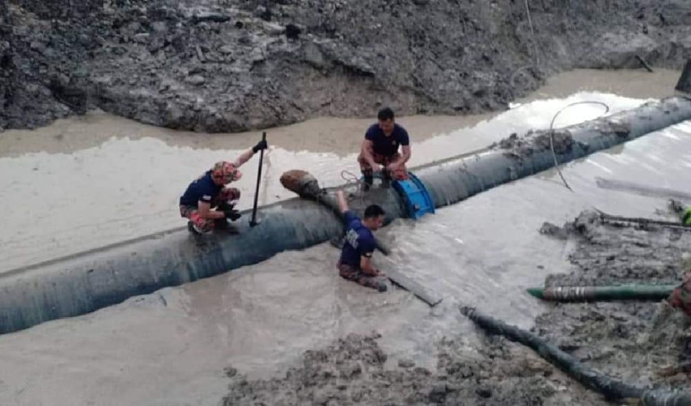 Anggota bomba Miri melakukan kerja pengepaman air di lokasi saluran paip bocor.