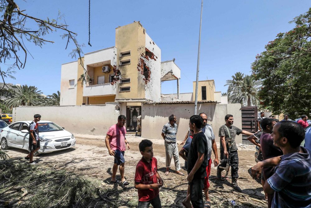 Orang ramai melihat kerosakan yang disebabkan oleh pertempuran di antara kumpulan bersenjata baru-baru ini di kawasan kejiranan Tripoli ibu kota Libya. - Gambar AFP