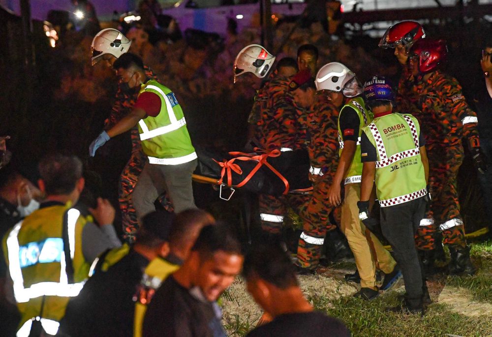 Anggota Jabatan Bomba dan Penyelamat mengeluarkan mayat jurulatih penerbangan yang maut selepas pesawat ringan jenis Piper 28 terhempas di Medan Gopeng pada Isnin malam. - Gambar BERNAMA