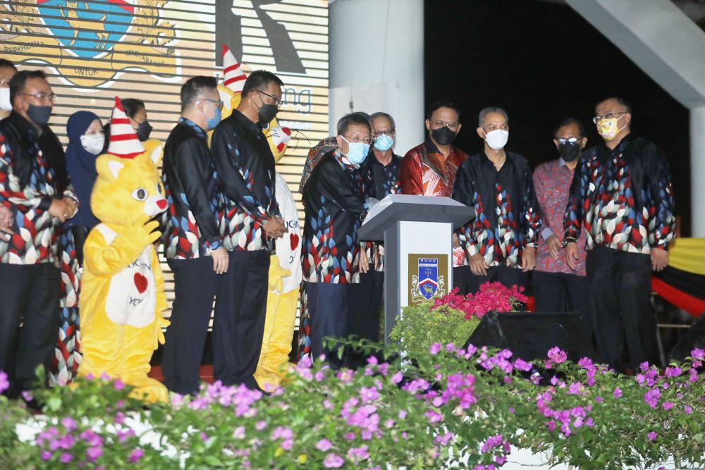 Dr Sim (tengah) simbolik bejadi Pesta Ria Festival Kuching 2022. Sama bisi dipeda dia, Abdul Karim (kanan Dr Sim) enggau bala menteri kabinet negeri Sarawak ke bukai.