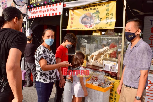 Pengunjung teruja melihat dan mendapatkan sedikit maklumat berkaitan hidangan makanan berasaskan buaya yang dijual di Festival Makanan Kuching 2022. - Gambar Roystein Emmor