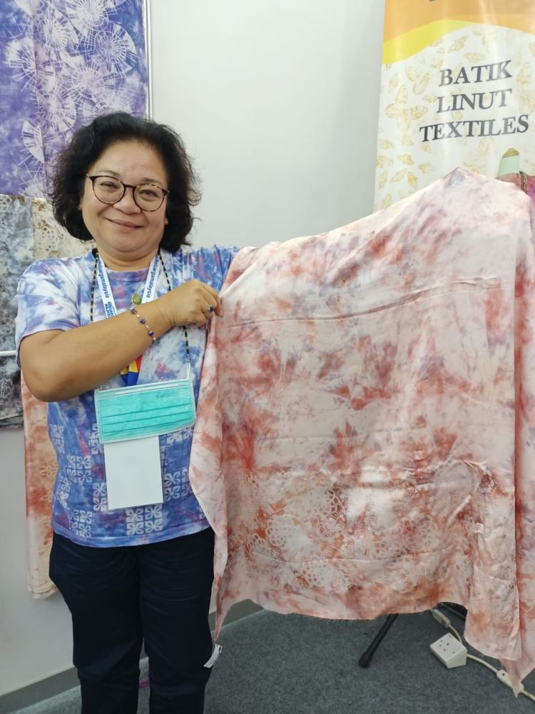 Diana menunjukkan kain sutera Batik Linut yang dihasilkannya di ruang pempamer Jelajah Aspirasi Keluarga Malaysia (JAKM) 2022 di Dataran Perayaan hari ini.