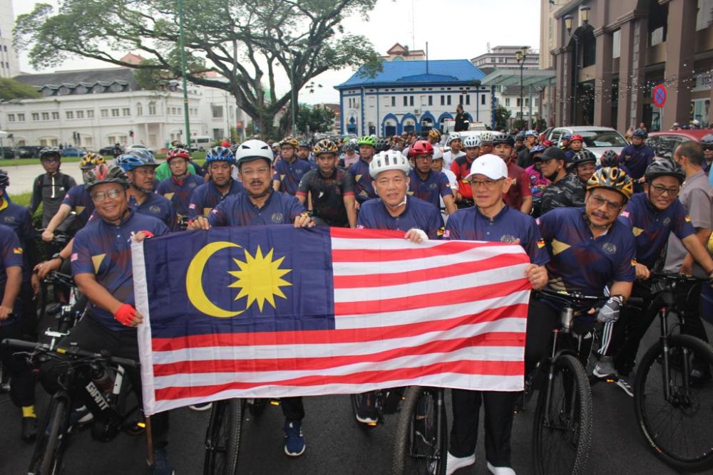 (Dari kiri) Mohamad Abu Bakar, Mohd Zuki, Fadillah dan Ibrahim bergambar dengan bendera Malaysia sebelum melepaskan peserta kayuhan berbasikal di Padang Merdeka, pagi tadi.
