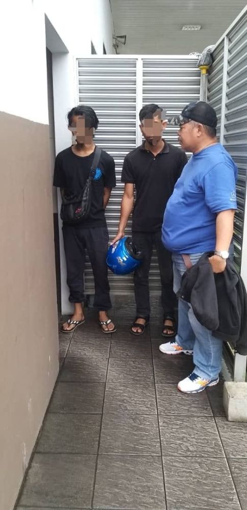 Kedua-dua suspek (kiri dan tengah) ketika pemeriksaan polis di sebuah stesen minyak di Mukah.