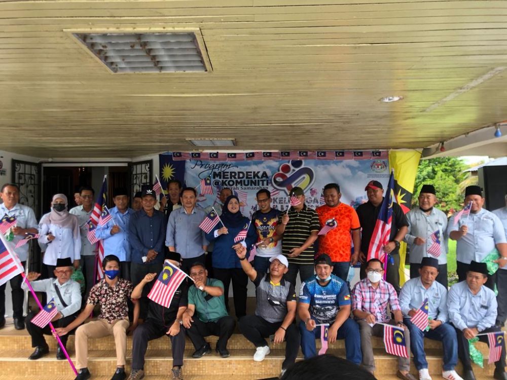 Rubiah bergambar bersama peserta konvoi dan ketua masyarakat pada Program Merdeka@Komuniti Konvoi Kembara Merdeka di Pejabat Daerah Samarahan hari ini.