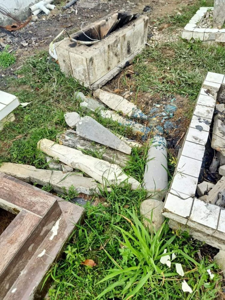Batu nisan di Tanah Perkuburan Islam Al-Qadim yang dicabut oleh seorang lelaki.