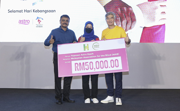  Henry (kanan) menyampaikan tajaan berjumlah RM50,000 dari Yayasan Astro Kasih kepada George (kiri) dan Nurin (tengah) yang mewakili MAB.