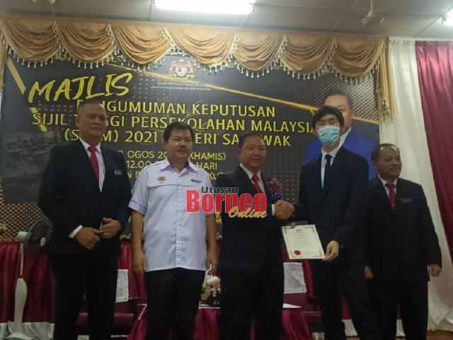Dr Azhar (tiga kiri) menyampaikan sijil cemerlang kepada Bryan Lim Kien Seng dari SMK Sacred Heart Sibu yang diiktiraf sebagai calon terbaik  STPM 2021 Negeri Sarawak.