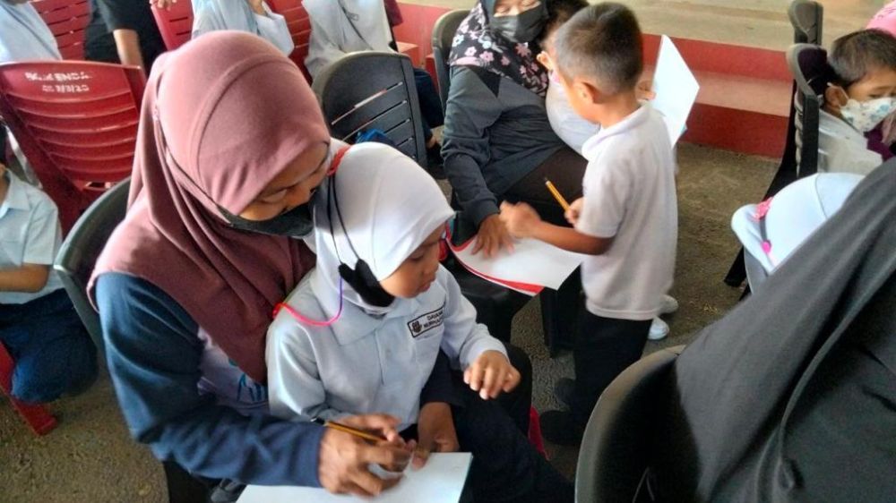Ibu bapa dan murid SK Endap mengikuti aktiviti bagi meningkatkan literasi dalam kalangan anak-anak.