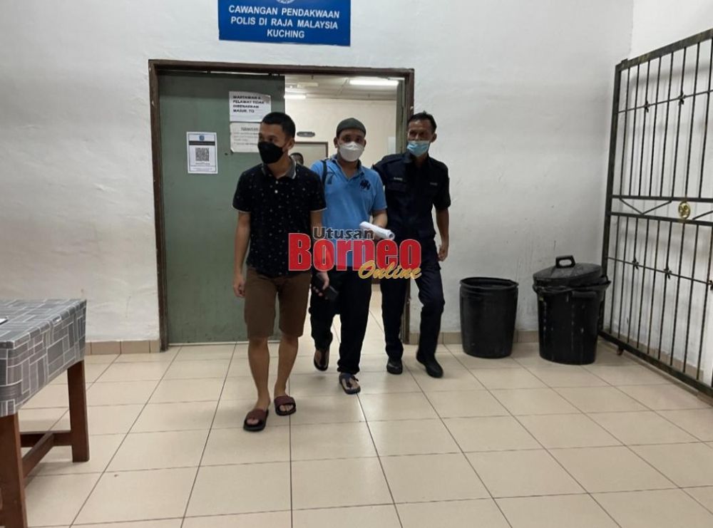 Tertuduh Mukhsin (tengah) diiring polis keluar dari bilik tahanan mahkamah Kuching hari ini.