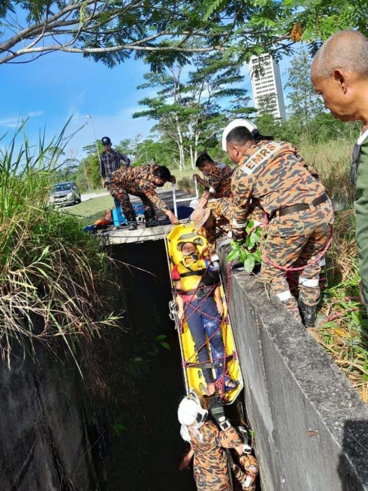 Mangsa diangkat keluar dari longkang sebelum dihantar ke hospital.