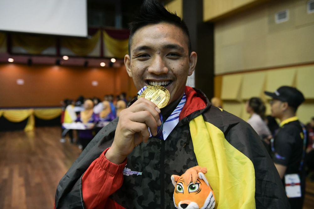 Abdul Latif bergambar bersama pingat emas yang berjaya diraihnya.