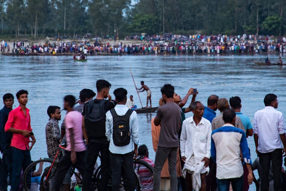  Penduduk membanjiri tebing Sungai Karatoya ketika operasi mencari dan menyelamat mangsa bot karam di bandar Boda, kelmarin. - Gambar AFP