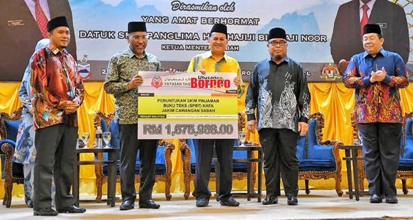  Mohd Arifin (tengah) menerima replika cek peruntukan Skim Pinjaman Buku Teks KAFA daripada Idris (dua kiri) pada majlis itu.