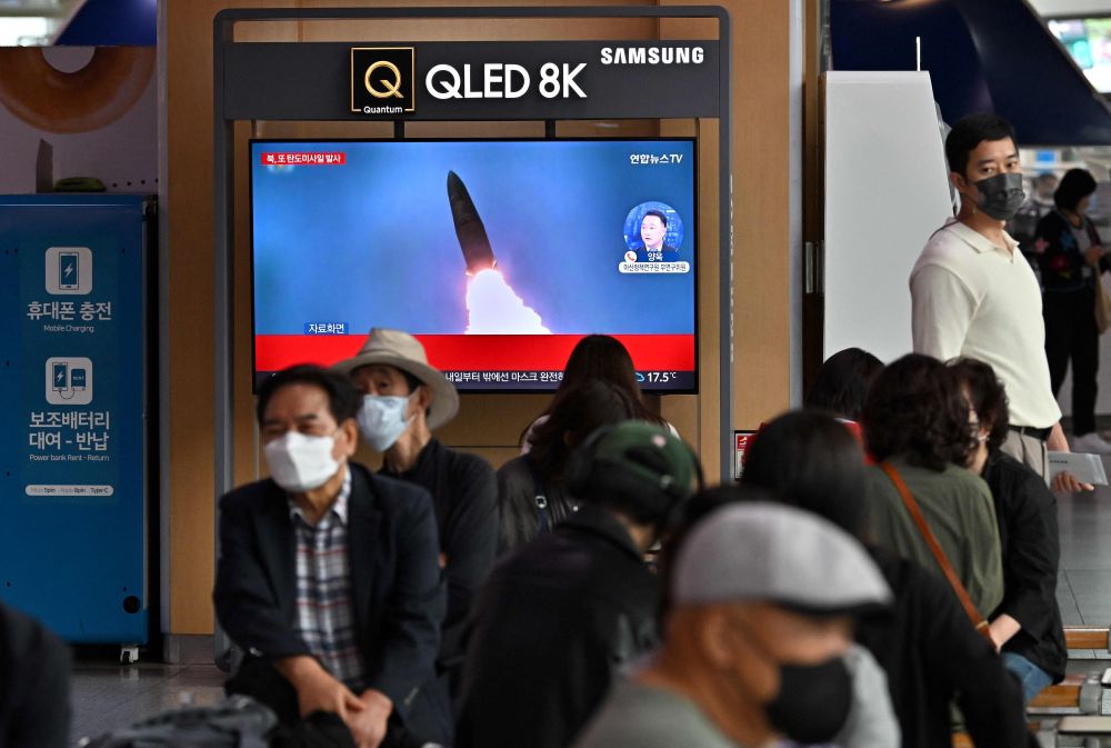  Orang ramai menonton skrin televisyen yang memaparkan siaran berita dengan rakaman fail ujian misil Korea Utara di stesen kereta api di Seoul, semalam. - Gambar AFP