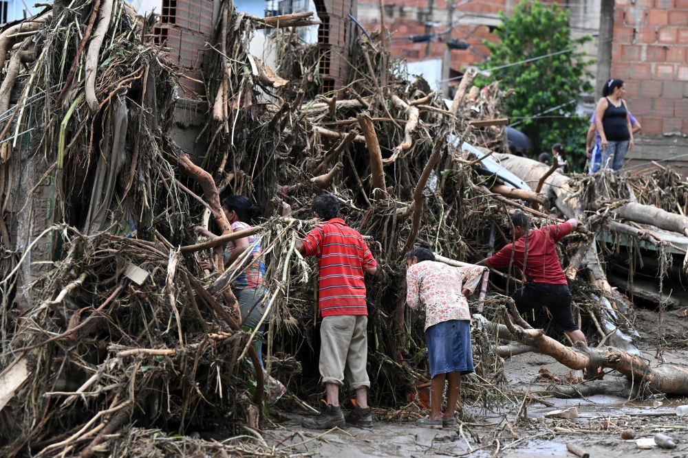 Penduduk menggeledah puing untuk mencari ahli keluarga yang hilang susulan tanah runtuh semasa hujan lebat melanda Las Tejerias di negeri Aragua, kelmarin. — Gambar AFP