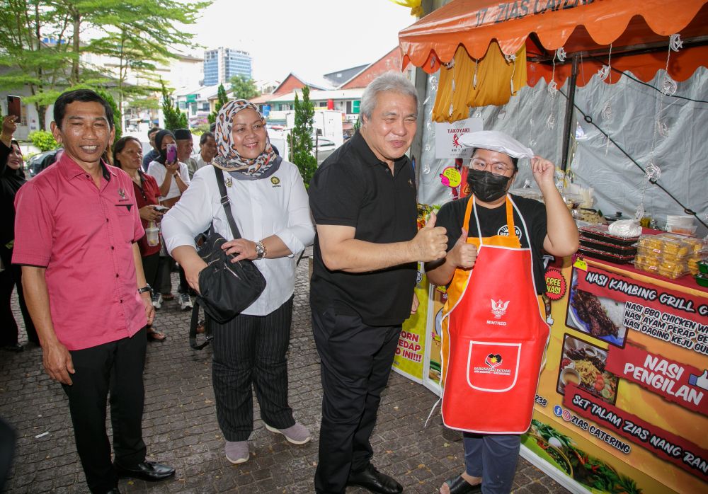 Awang Tengah nyuaka apron ari MINTRED ngagai orang dagang ke ngambi bagi ba pengawa dagang ba Sarawak Kitchen, kemari. -Gambar Muhammad Rais Sanusi