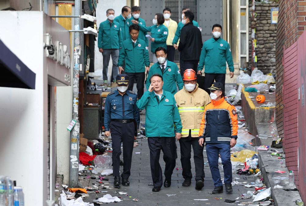 Yoon (dua kiri) melawat tempat kejadian di lorong sempit berhampiran sebuah hotel di daerah Itaewon, Seoul semalam. - Gambar AFP