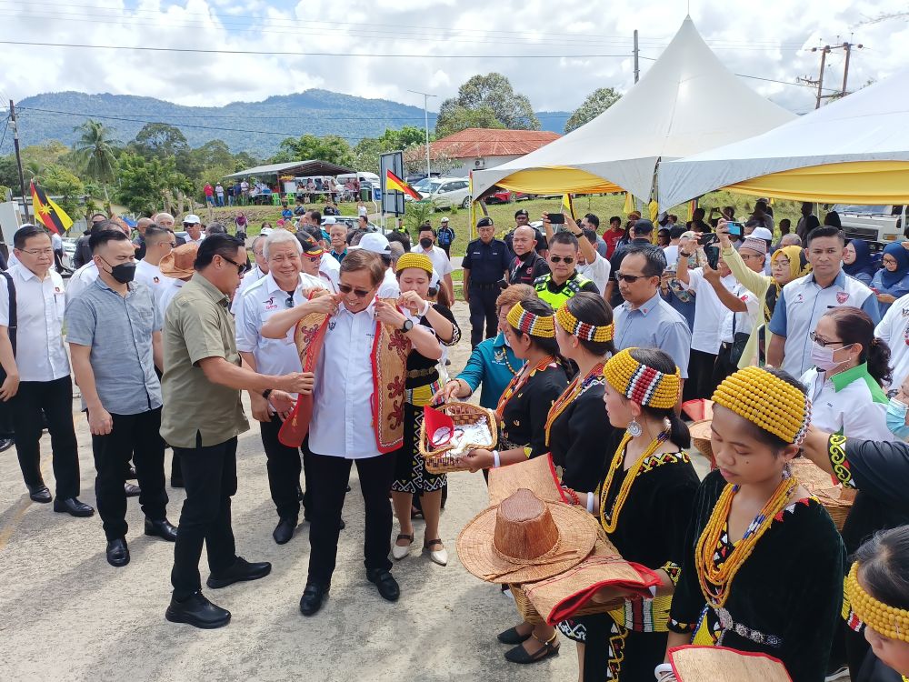 Abang Johari (tengah) disambut enggau basa  peranak Kampung Long Tuma, Lawas kemari seraya dirasukka baju tradisional raban bansa Lun Bawang. 