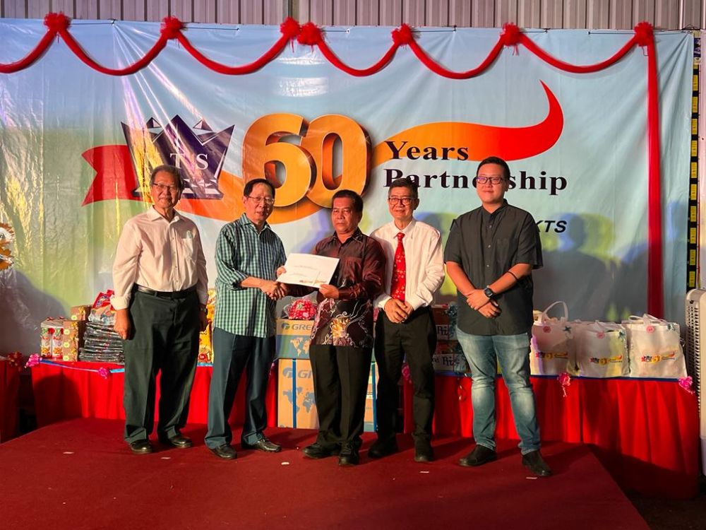 Lau (dua kiri) menyampaikan Anugerah Perkhidmatan Setia kepada Maja Unjong (tengah) dari Kinetic Food Processing Sdn Bhd yang telah berkhidmat selama 30 tahun sambil diperhatikan oleh Peter Lau (kiri), Wong (dua kanan) dan Kevin (kanan).