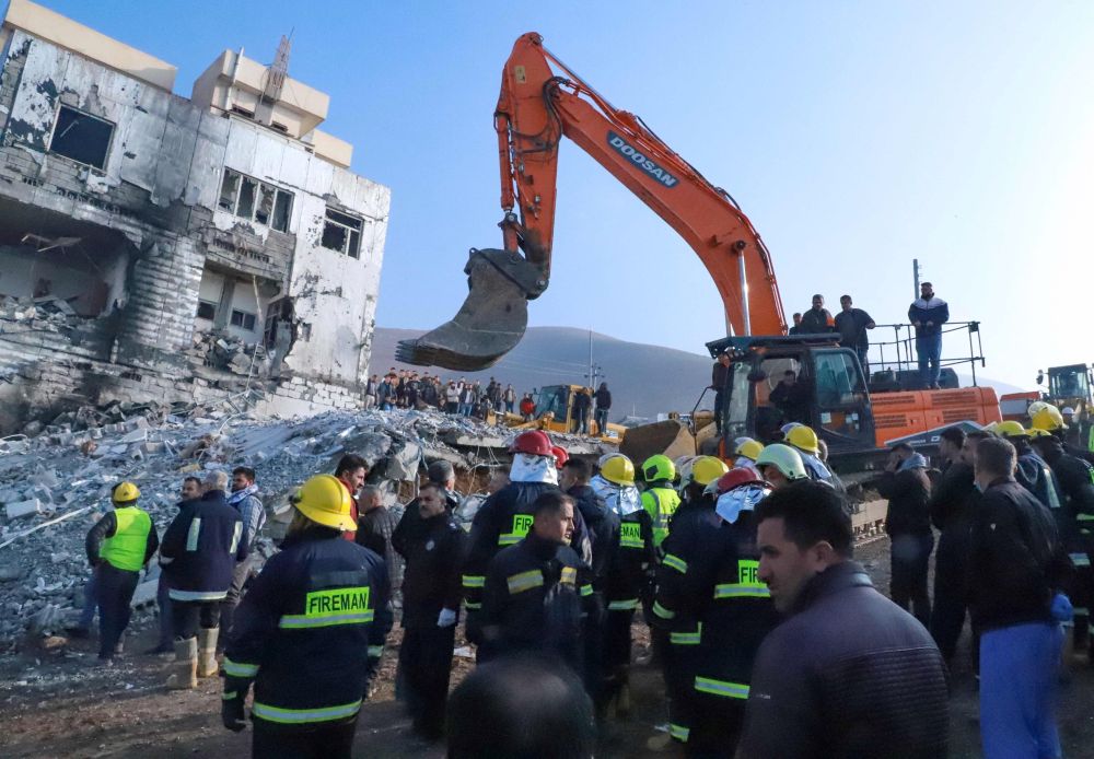 Orang ramai berkumpul ketika anggota bomba menggeledah runtuhan bangunan untuk mencari mangsa terselamat selepas letupan tangki gas di bandar  Sulaimaniyah, di utara Iraq kelmarin. — Gambar AFP