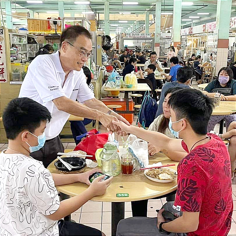 Wong (kiri) mengucapkan terima kasih kepada pengunjung di Pasar Sentral Sibu hari ini.
