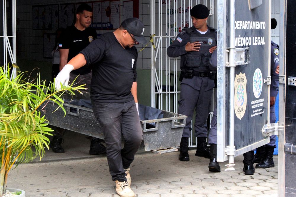 Pakar jenayah mengangkat mayat mangsa yang terbunuh dalam insiden tembakan di sekolah di Aracruz, Negeri Espirito Santo, Brazil kelmarin. — Gambar AFP