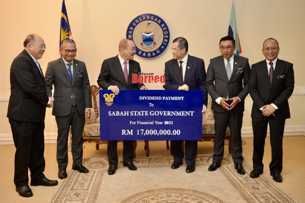  Hajiji (tiga kiri) menerima dividen berjumlah RM17 juta daripada Pengerusi Sabah Credit Corporation Datuk Seri Panglima Dr Yee Moh Chai (tiga kanan).