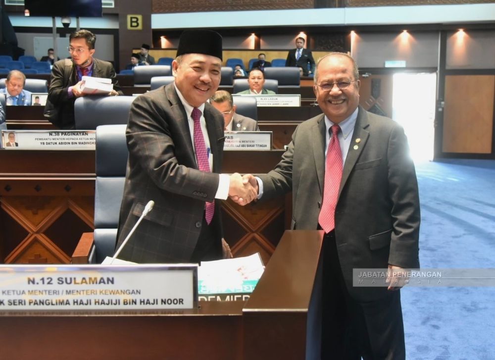  Abidin (kanan) bersalam dengan Ketua Menteri Datuk Seri Panglima Hajiji Haji Noor ketika dalam Dewan Undangan Negeri (DUN) hari ini.