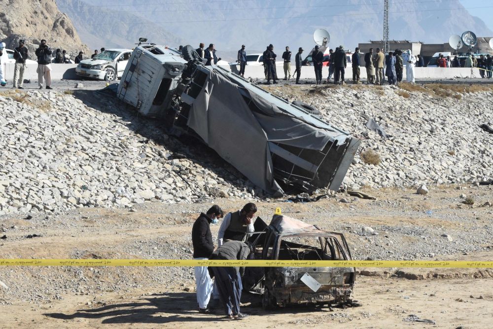 Pegawai pasukan keselamatan memeriksa rangka kereta yang rentung selepas serangan bom nekad yang menyasarkan trak polis di Quetta, kelmarin. — Gambar AFP