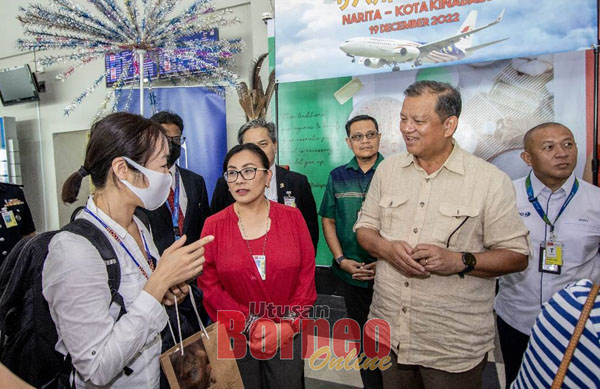  Joniston (dua kanan), Noredah (dua kiri) semasa menyambut penumpang pertama dari Jepun di Lapangan Terbang KK.