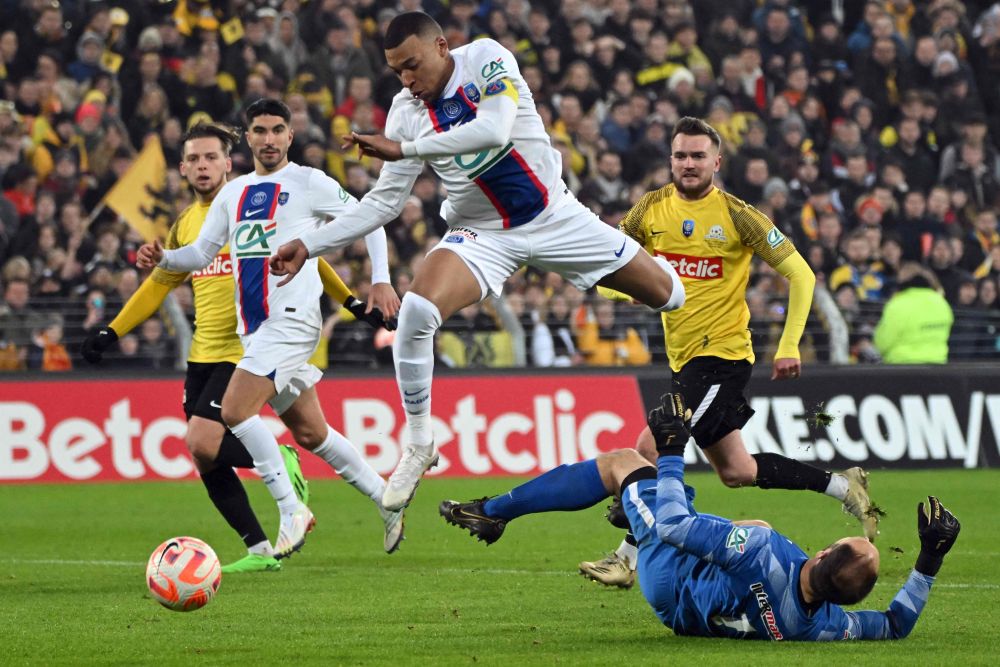 Mbappe melompat untuk mengelak penjaga gol Pays de Cassel Romain Samson ketika menjaringkan gol pada perlawanan Piala Perancis peringkat 32 akhir di antara Pays de Cassel dan PSG di  stadium Bollaert-Delelis di Lens, kelmarin. — Gambar AFP