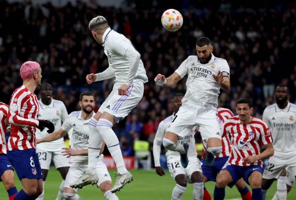 Benzema (atas, kanan) menanduk bola pada perlawanan separuh akhir Copa del Rey di antara Real Madrid dan Atletico de Madrid di stadium Santiago Bernabeu di Madrid, kelmarin. — Gambar AFP