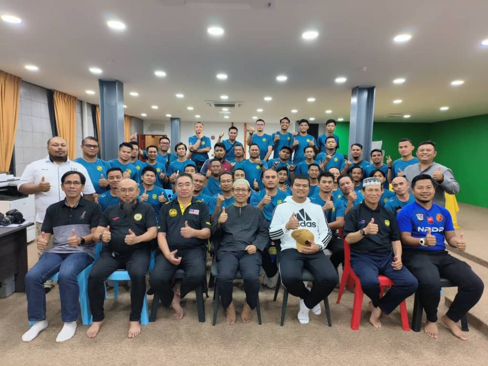 Abang Zulkarnain (duduk, empat kiri) bergambar bersama peserta Kursus Kejurulatihan Bola Sepak Lesen FAM 2023 malam Rabu.