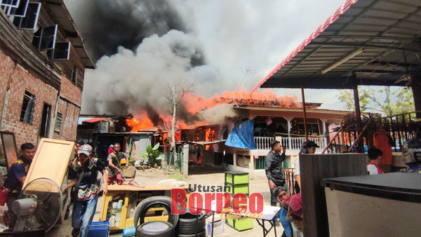  Kelihatan beberapa penduduk berusaha menyelamatkan harta benda masing-masing selepas rumah mereka terbakar.