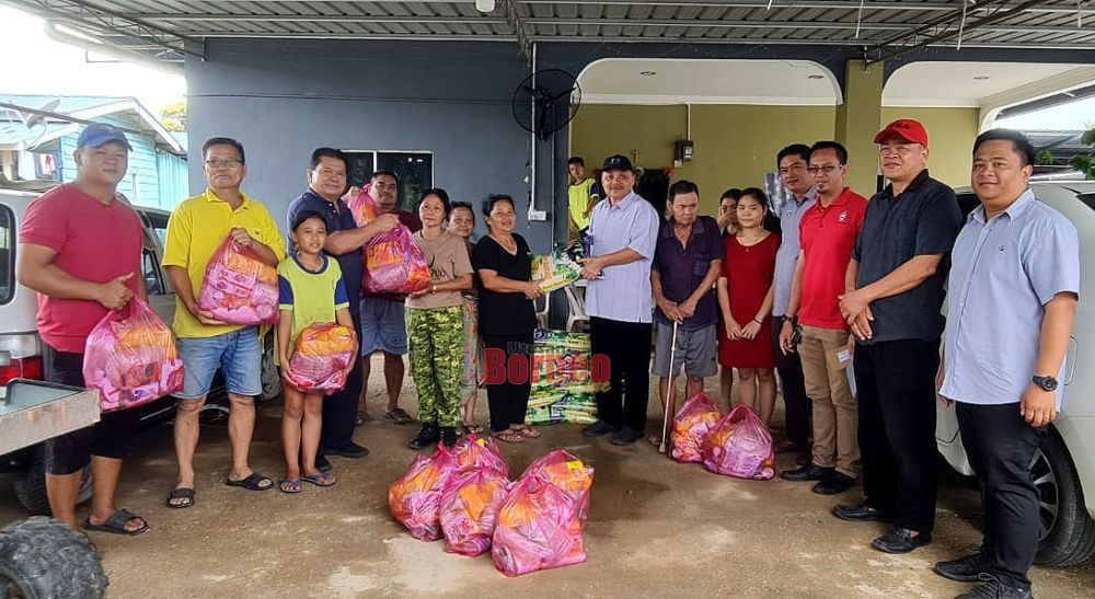  Robert (tujuh kanan) menyerahkan sumbangan kebajikan kepada sebahagian mangsa banjir di Kampung Ranggom sempena program turun padang itu.