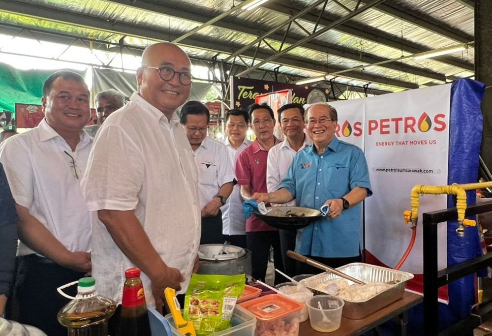 Uggah menunjukkan kuetiau gorengnya kepada pemberita. Beliau menjadi antara pengguna awal gas paip yang mula disalurkan untuk kegunaan 67 peniaga Medan SABERKAS Miri hari ini. Turut kelihatan, (dari kiri) Janin, Yii, Lee serta yang lain.