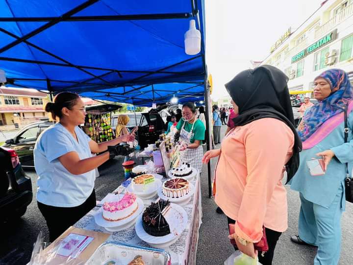 Norazah (kanan) meninjau usahawan yang menyertai program berkenaan.