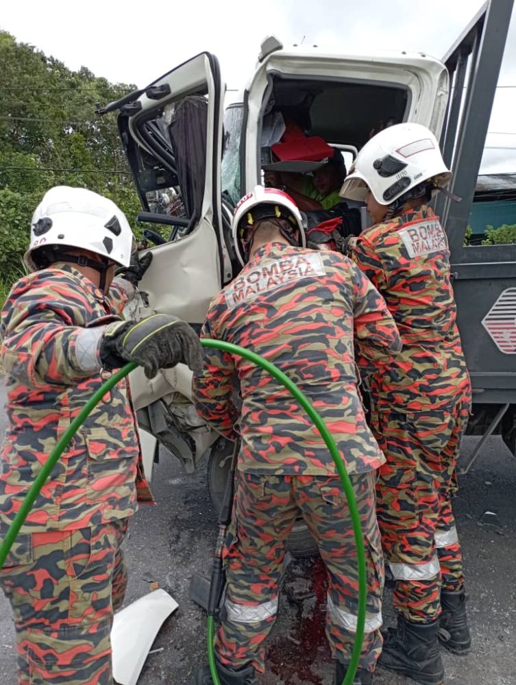 Pasukan bomba sedang berusaha mengeluarkan mangsa yang tersepit dalam satu kemalangan yang melibatkan dua buah lori di kawasan Tanjung Genting, Bintangor, pada Sabtu.