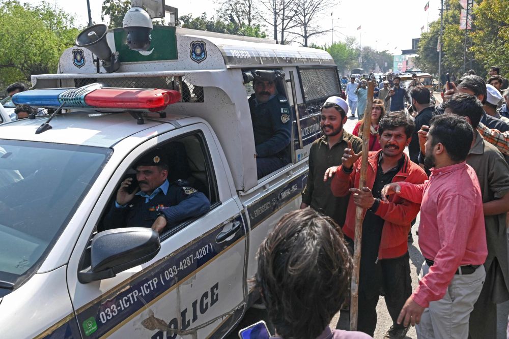 Para penyokong Imran Khan berkumpul mengelilingi van polis di luar rumah bekas perdana menteri Pakistan itu di Lahore, kelmarin.  — Gambar AFP