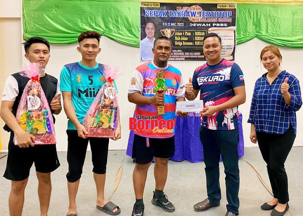  Shahril (dua kanan) menyampaikan hadiah kepada salah satu pasukan yang menyertai Kejohanan Sepak Takraw Tertutup Pedalaman Bawah.