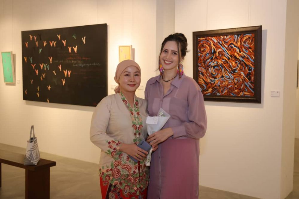  Alena (kanan) merakam kenangan bersama Pereka Fesyen Sarawak Neng Kho Razali (kiri) di pameran 'Colours of the Highlands' di Galeri Hoan, La Promenade Mall malam tadi.