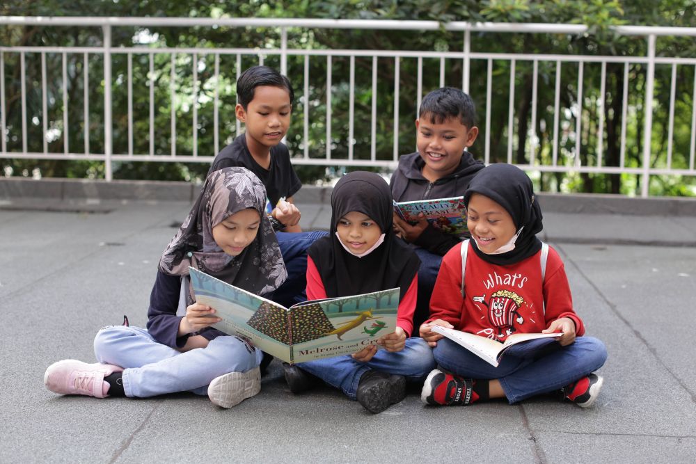  Kanak-kanak PPR Seri Alam membaca buku cerita pada pelancaran Projek BacaBaca pada Jun 2022.