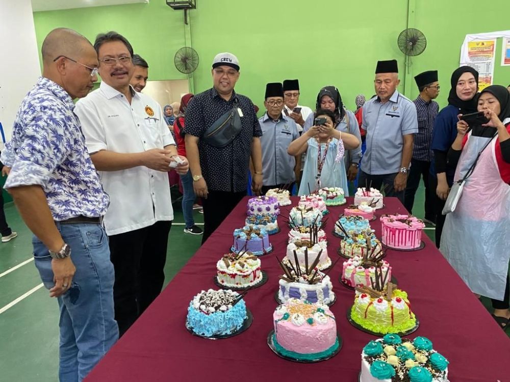 Hazland melihat hasil tangan peserta Kursus Kemahiran Jangka Masa Pendek pada majlis perasmian di Dewan Serbaguna Kampung Muara Tebas pada Ahad.