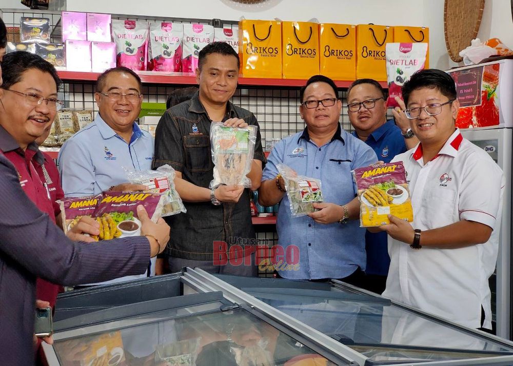  Ewon (kanan) menunjukkan produk yang dijual di IKS Mart Koperasi Usahaniaga Kota Marudu Berhad.