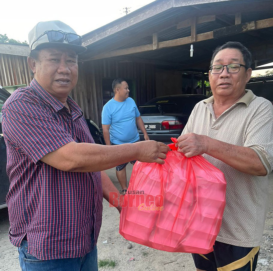  Erick (kiri) yang mewakili Annuar menyerahkan sumbangan Moreh kepada penerima di Surau Al falah Kg Kilambang Apin.