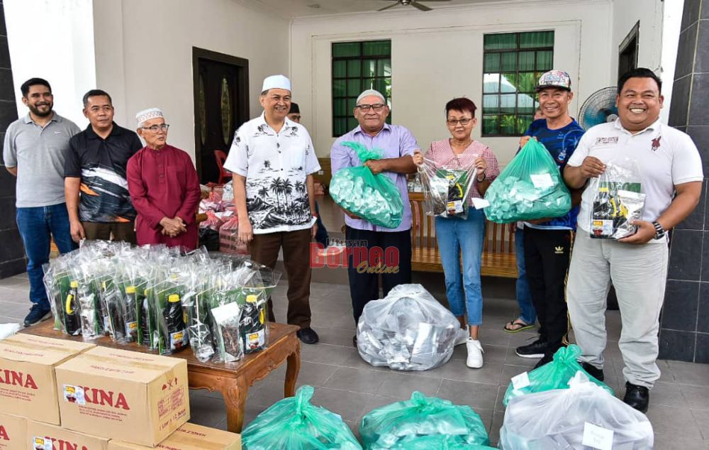  Arifin (empat kiri) menyampaikan pek Ramadan kepada salah seorang JPKK sempena program Bingkisan Ramadan yang diadakan.